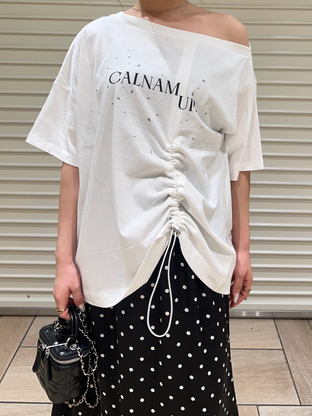 ホワイト系のTシャツ/カットソー、ブラック系のスカートを着用したレディースの夏コーディネートの6枚目の写真