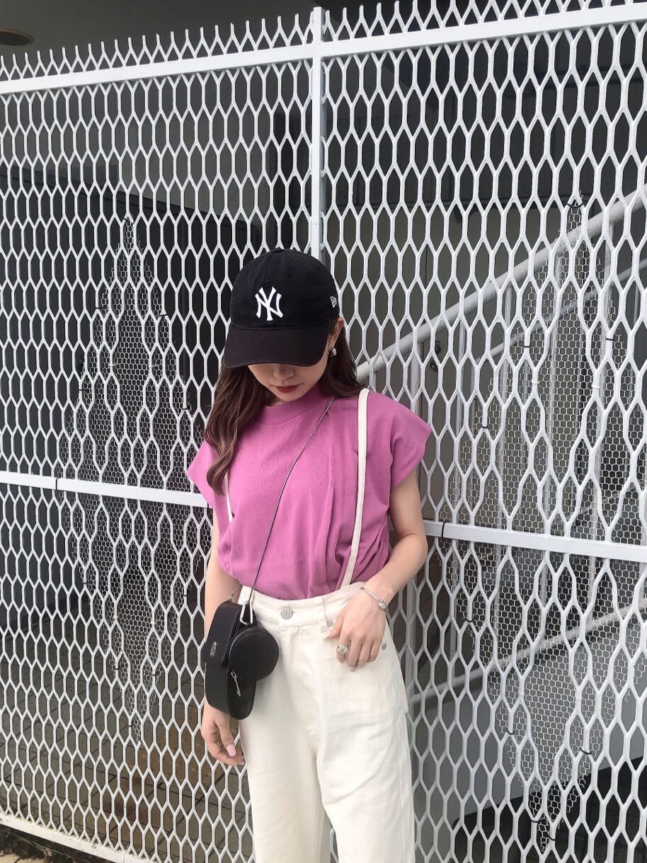 ピンク系のタンクトップ、ホワイト系のデニムパンツ、ブラック系のサンダルを着用したレディースの春コーディネートの4枚目の写真