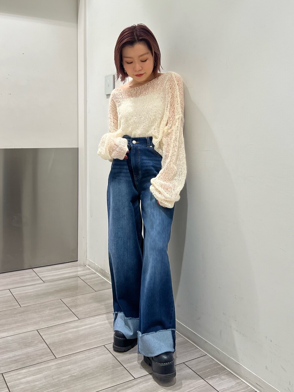 ブルー系のデニムパンツ、ホワイト系のニット/セーターを着用したレディースの秋コーディネートの3枚目の写真