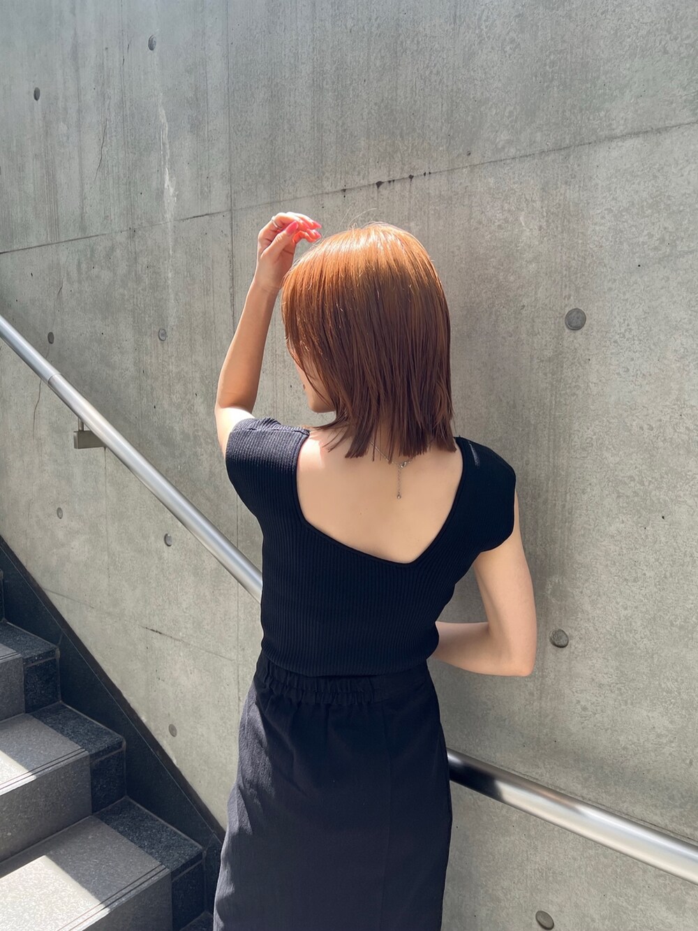 ブラック系のスカート、ブラック系のタンクトップ、ブラウン系のサンダルを着用したレディースの春コーディネートの6枚目の写真