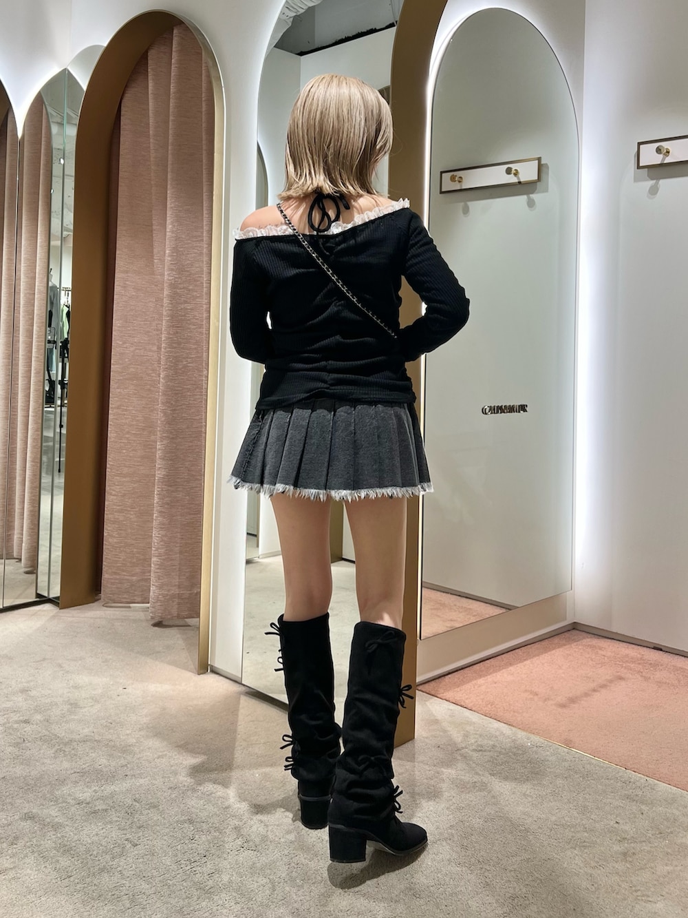 ブラック系のブーツ、ブラック系のスカートを着用したレディースの秋コーディネートの3枚目の写真