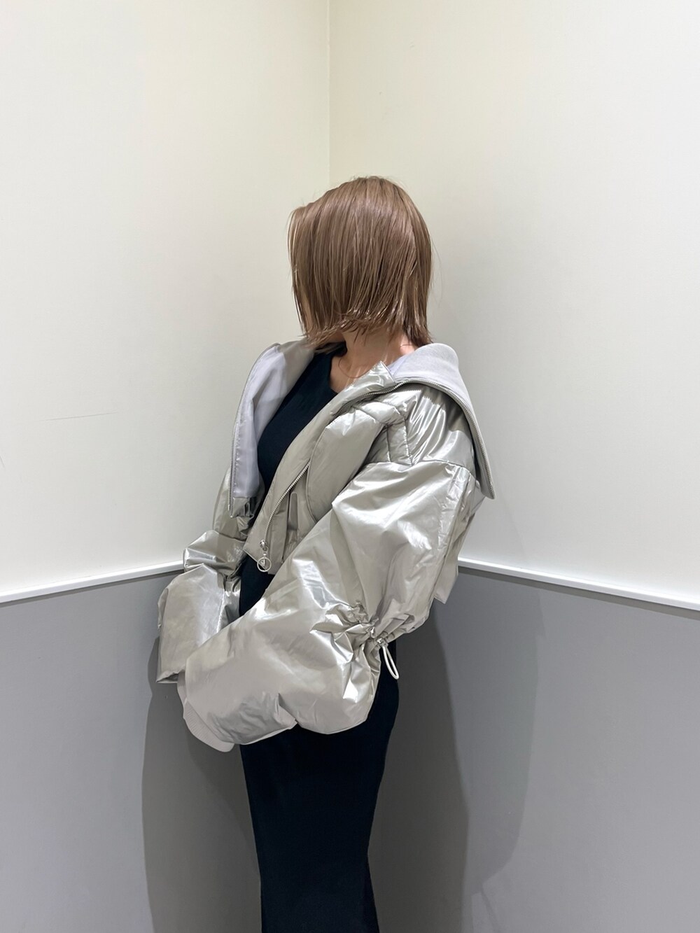 ブラック系のニット/セーター、シルバー系のブルゾン、ブラック系のスカートを着用したレディースの冬コーディネートの6枚目の写真