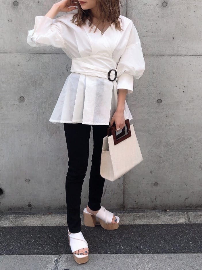 ホワイト系のサンダル、ブラック系のデニムパンツ、ホワイト系のハンドバッグを着用したレディースの春コーディネートの5枚目の写真