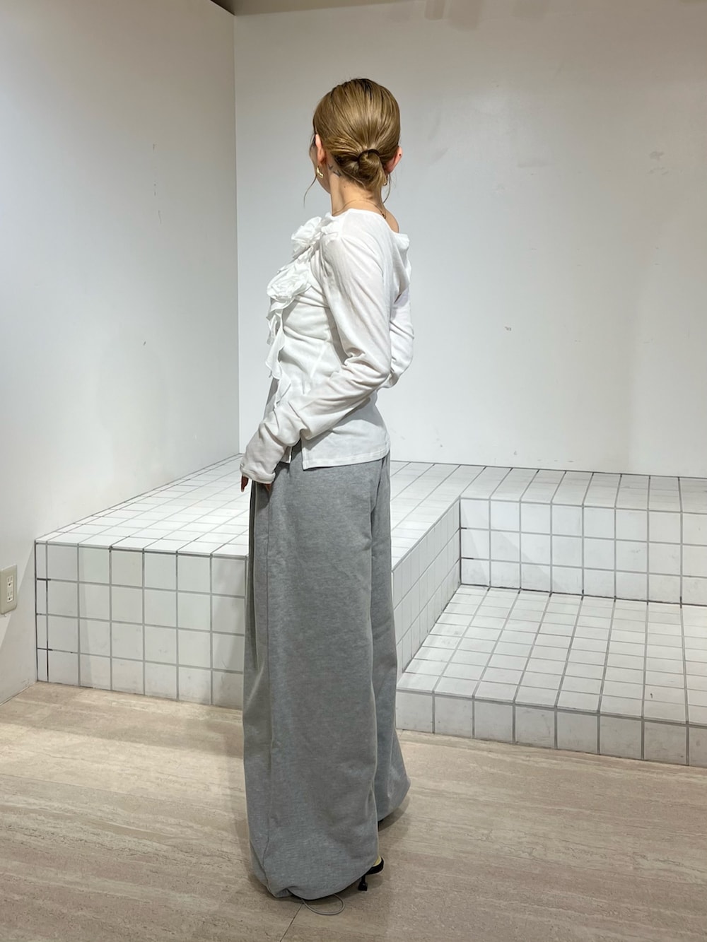 ホワイト系のTシャツ/カットソー、グレー系のその他パンツ、ブラック系のサンダルを着用したレディースの春コーディネートの2枚目の写真
