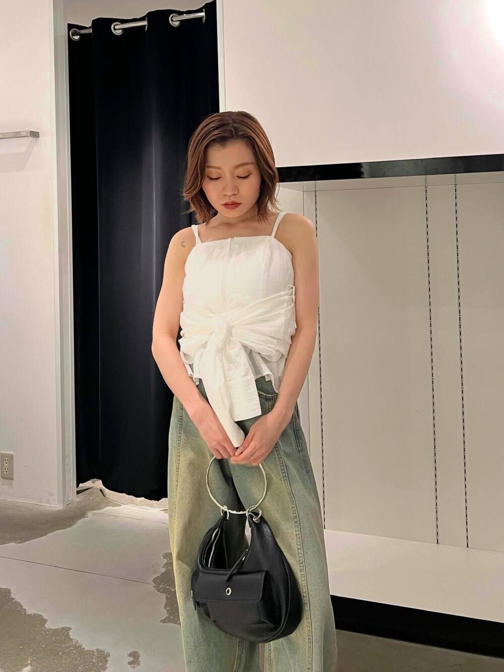 ホワイト系のシャツ/ブラウス、ブルー系のデニムパンツ、シルバー系のパンプスを着用したレディースの夏コーディネートの5枚目の写真