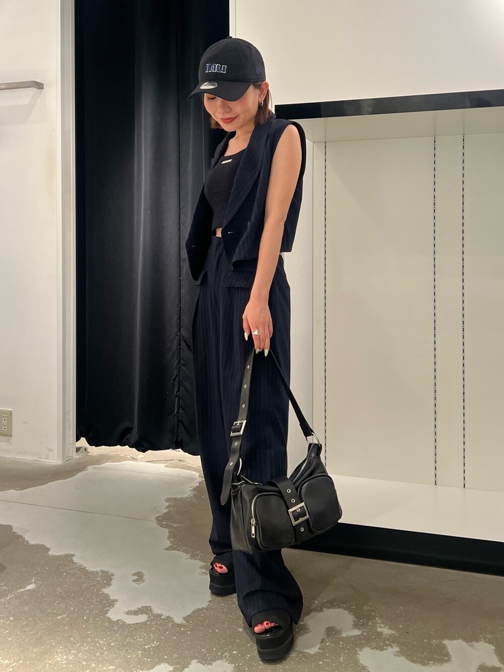 ブルー系のベスト、ブルー系のその他パンツ、ブラック系のキャミソールを着用したレディースの夏コーディネートの3枚目の写真