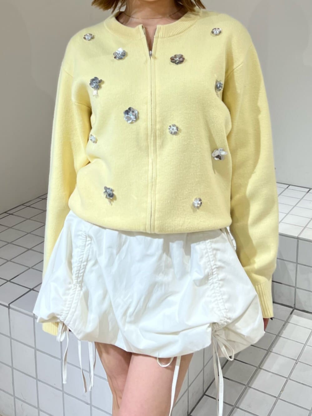 イエロー系のカーディガン/ボレロ、ホワイト系のスカートを着用したレディースの冬コーディネートの5枚目の写真