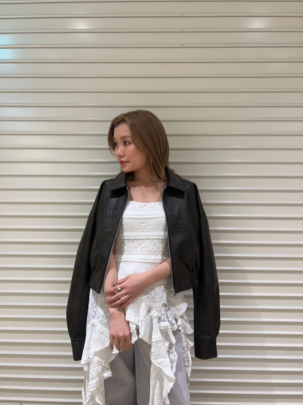 ブラウン系のサンダル、ブラウン系のブルゾン、ホワイト系のワンピースを着用したレディースの春コーディネートの4枚目の写真