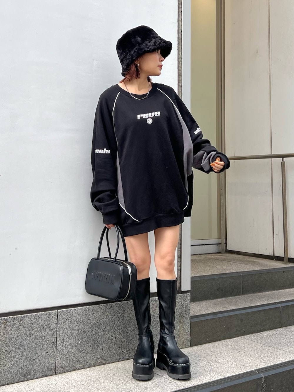 ブラック系のスウェット、ブラック系のブーツ、ブラック系のハットを着用したレディースの秋コーディネートの4枚目の写真