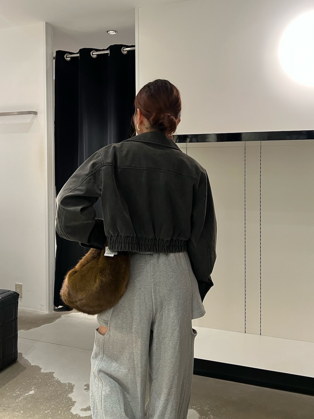 ブラック系のブルゾン、ホワイト系のTシャツ/カットソー、グレー系のスウェットパンツを着用したレディースの秋コーディネートの6枚目の写真