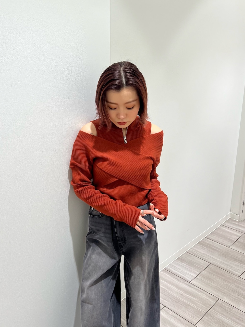 オレンジ系のニット/セーター、グレー系のデニムパンツを着用したレディースの冬コーディネートの4枚目の写真