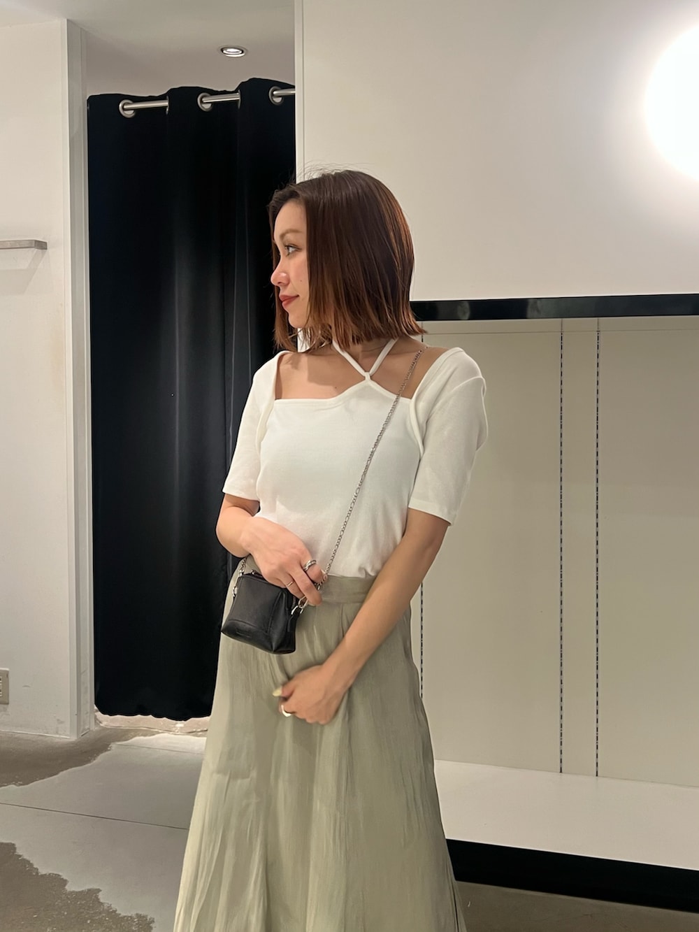 ブラック系のサンダル、ブラック系のショルダーバッグ、ホワイト系のTシャツ/カットソーを着用したレディースの夏コーディネートの4枚目の写真