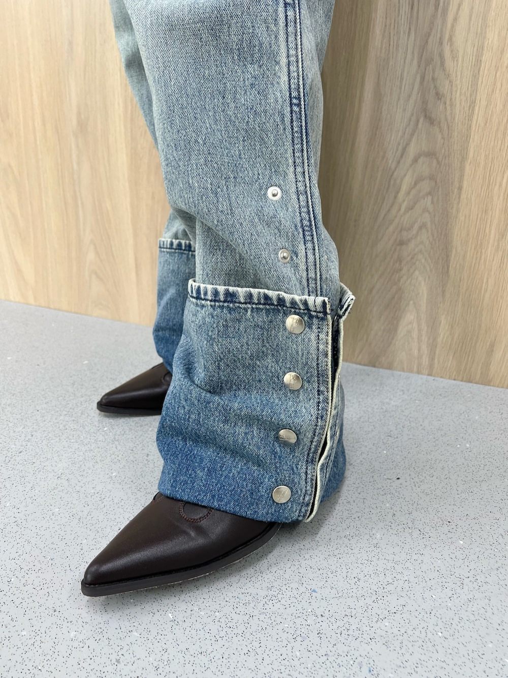 ホワイト系のタンクトップ、ブルー系のデニムパンツ、ブラウン系のブーツを着用したレディースの春コーディネートの5枚目の写真