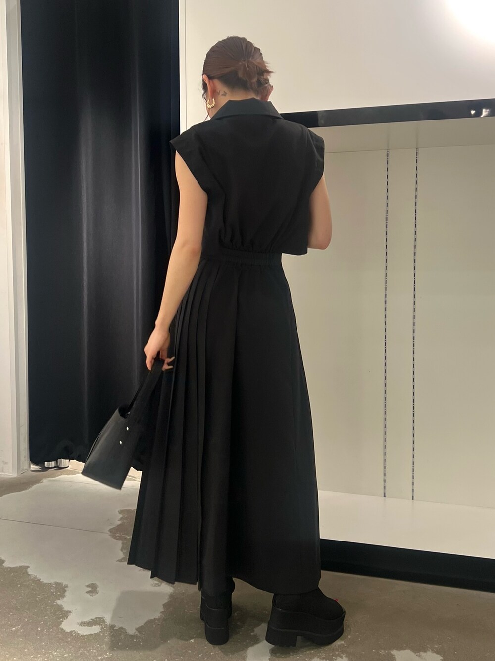 ブラック系のワンピース、ブラック系のサンダル、ブラック系のハンドバッグを着用したレディースの夏コーディネートの3枚目の写真