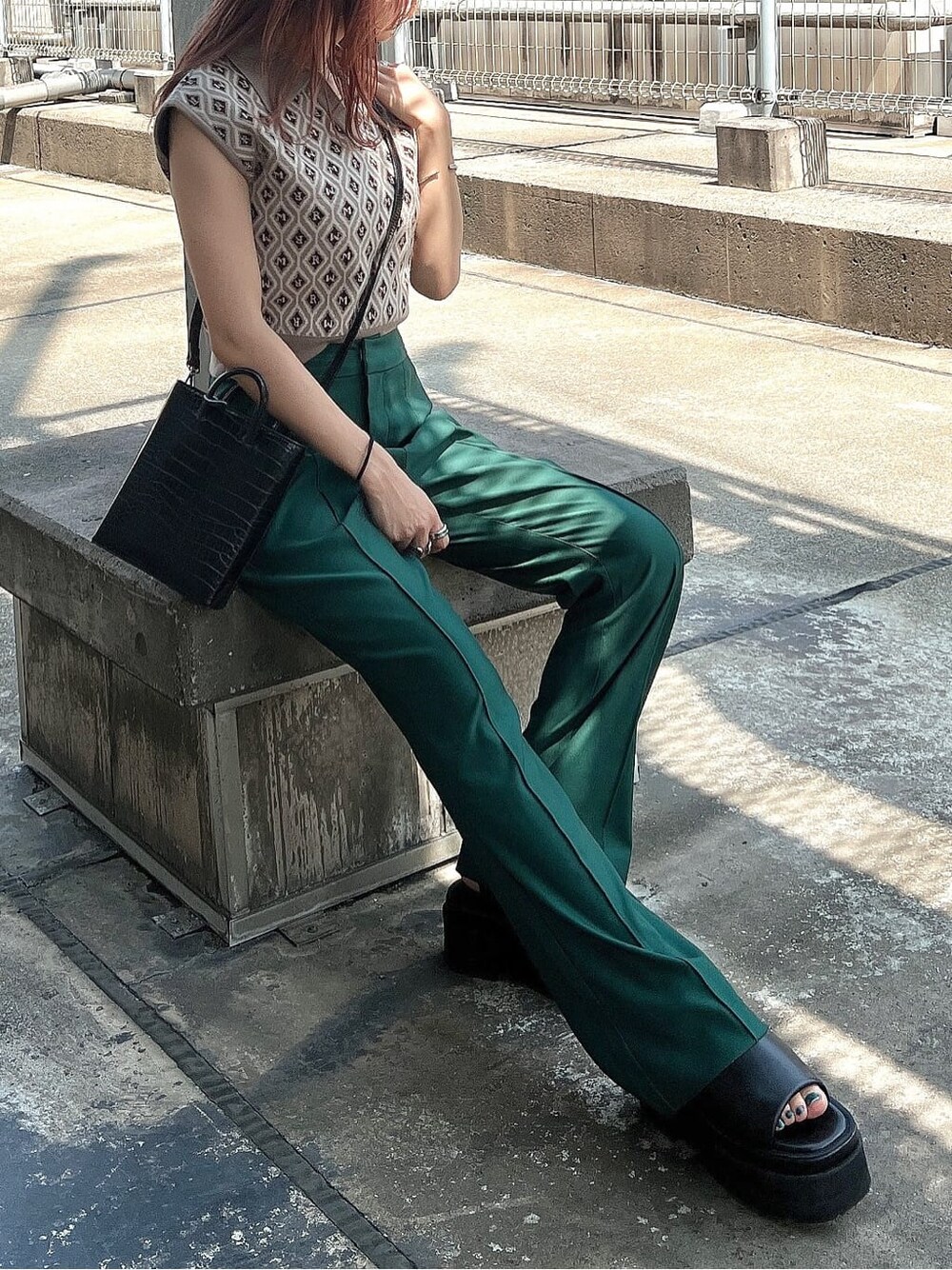 ベージュ系のニット/セーター、グリーン系のスラックスを着用したレディースの夏コーディネートの4枚目の写真