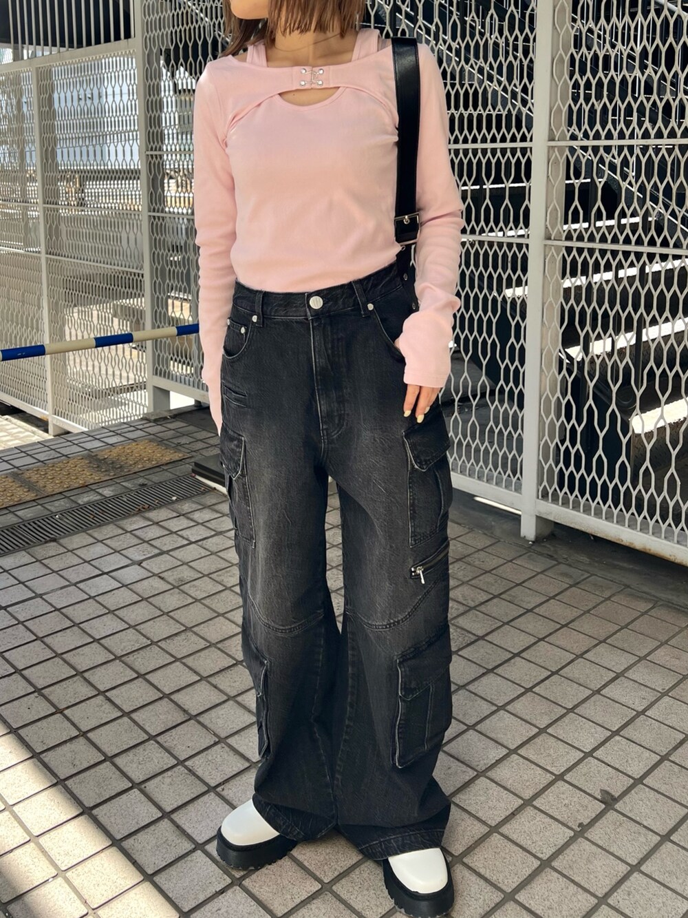 ピンク系のTシャツ/カットソー、ブラック系のデニムパンツ、ホワイト系のブーツを着用したレディースの冬コーディネートの5枚目の写真