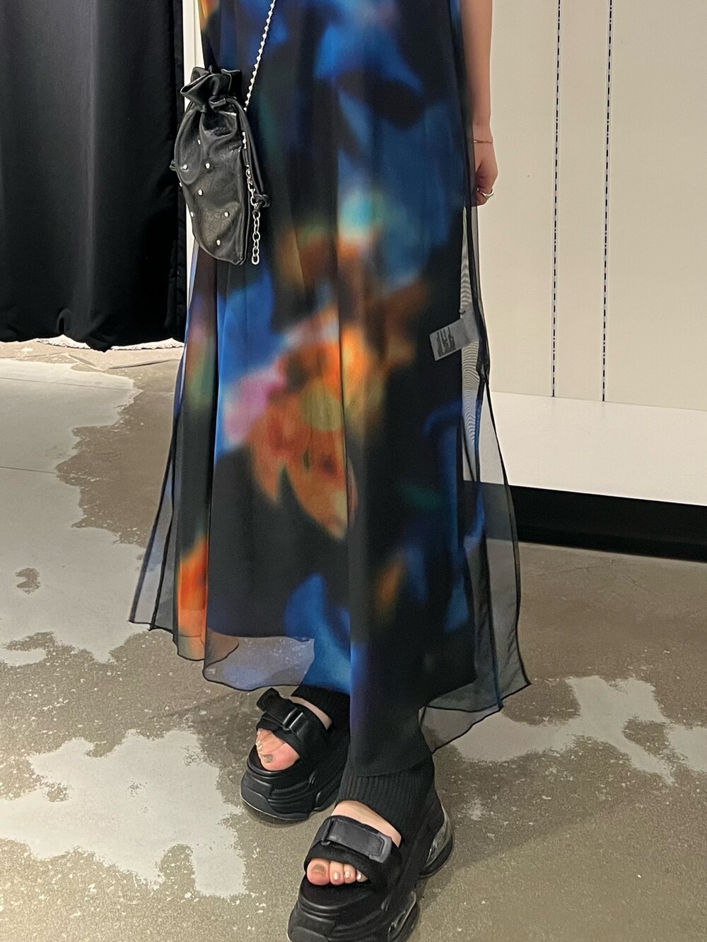 ブラック系のワンピース、ブラック系のサンダル、ブラック系のショルダーバッグを着用したレディースの春コーディネートの6枚目の写真