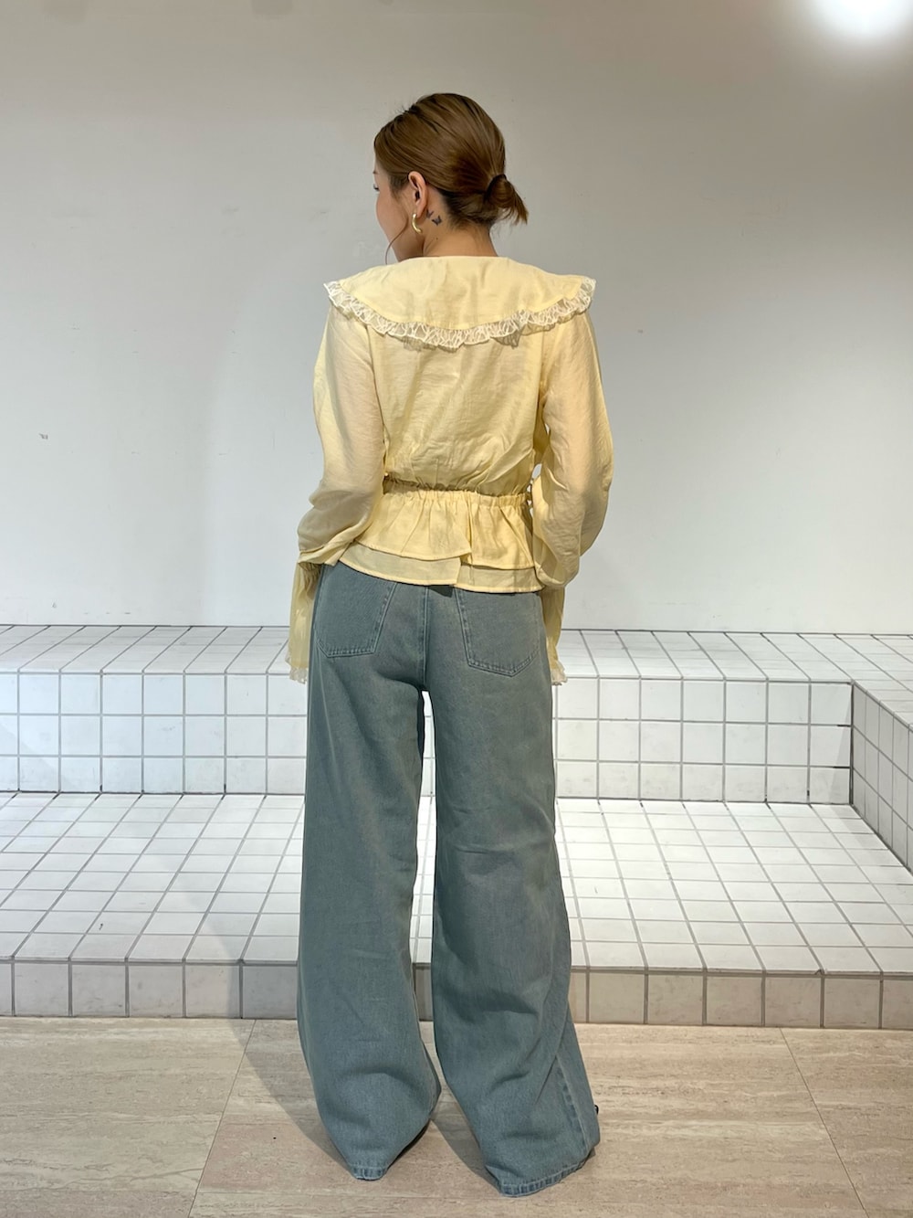 ブルー系のデニムパンツ、イエロー系のシャツ/ブラウス、ブラック系のサンダルを着用したレディースの春コーディネートの3枚目の写真