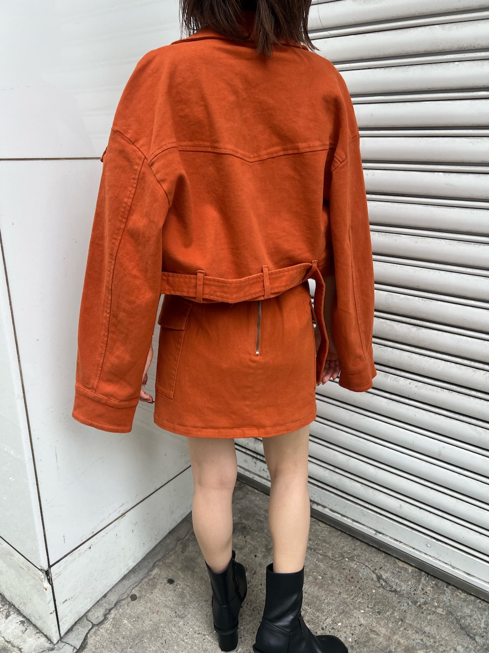 ホワイト系のニット/セーター、オレンジ系のデニムジャケット、オレンジ系のスカートを着用したレディースの夏コーディネートの6枚目の写真