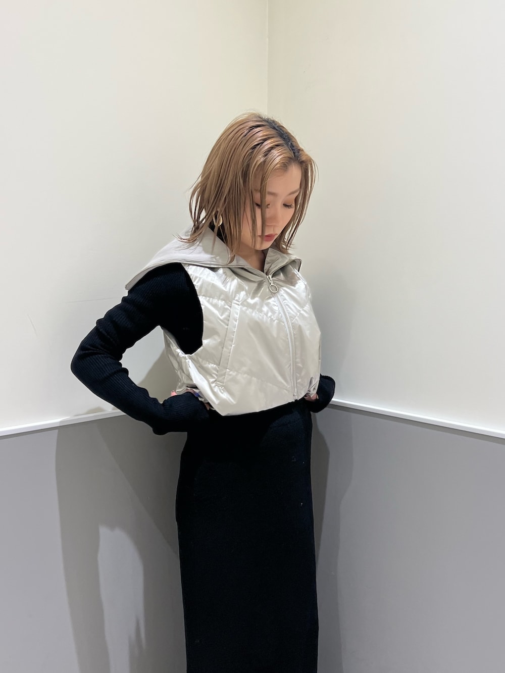 ホワイト系のブーツ、ブラック系のスカート、シルバー系のブルゾンを着用したレディースの冬コーディネートの6枚目の写真