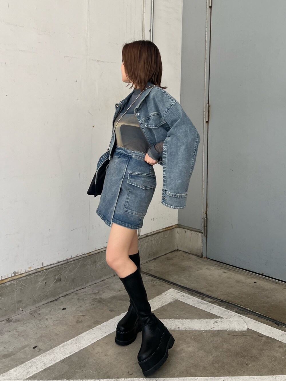 ブラック系のショルダーバッグ、ブラック系のブーツ、その他のTシャツ/カットソーを着用したレディースの夏コーディネートの3枚目の写真