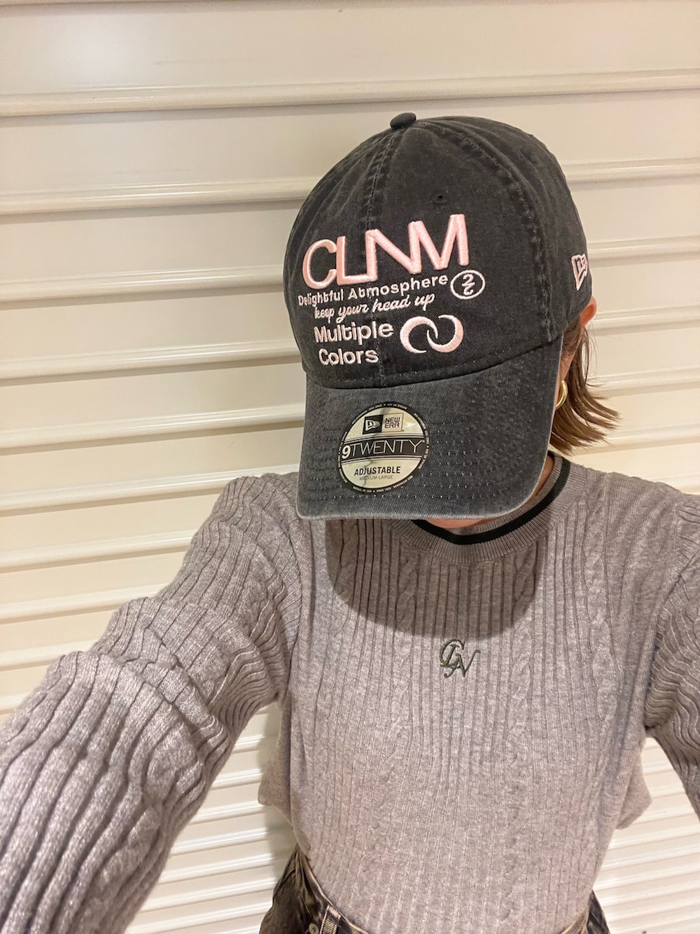 グレー系のニット/セーター、ブラック系のデニムパンツ、ブラック系のキャップを着用したレディースの冬コーディネートの6枚目の写真