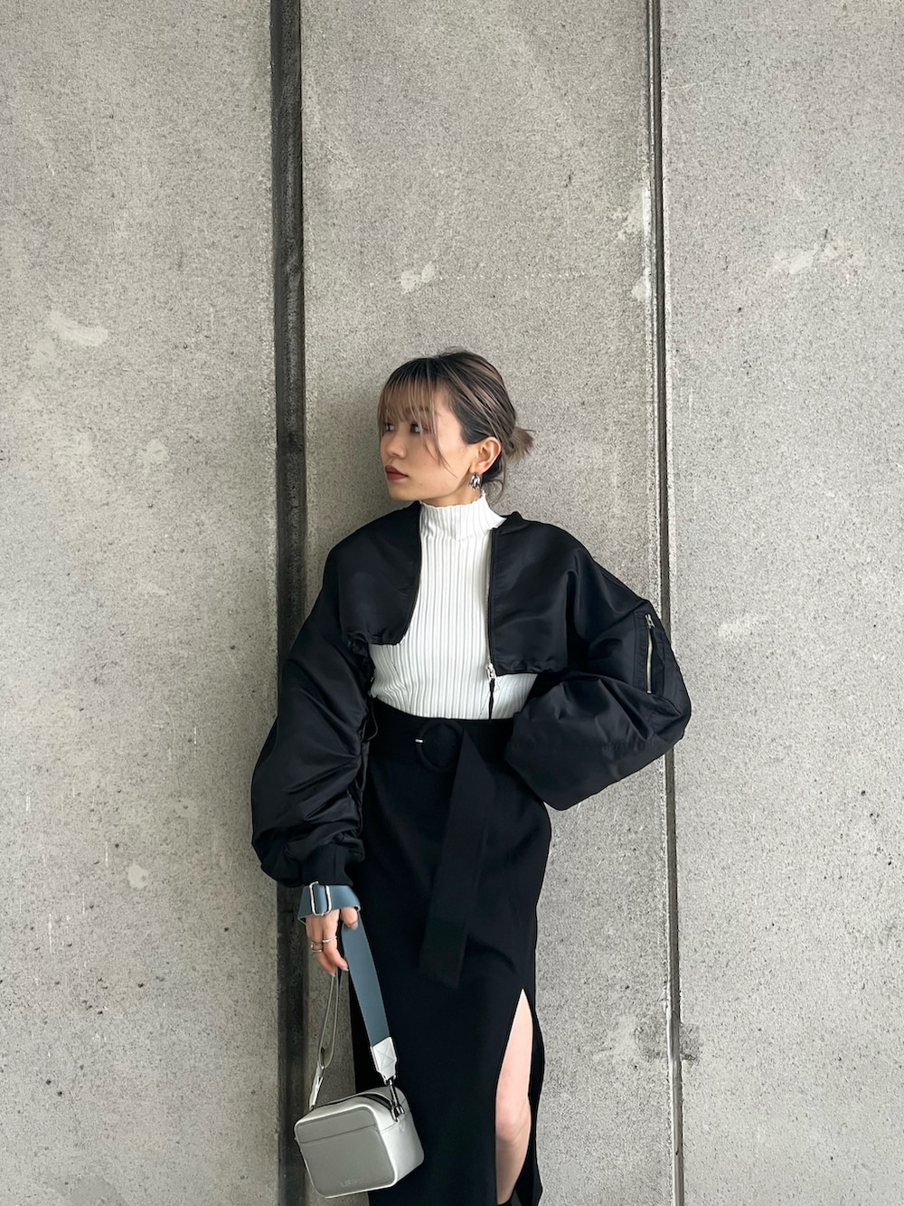 ブラック系のMA-1、ホワイト系のニット/セーター、ブラック系のスカートを着用したレディースの冬コーディネートの5枚目の写真