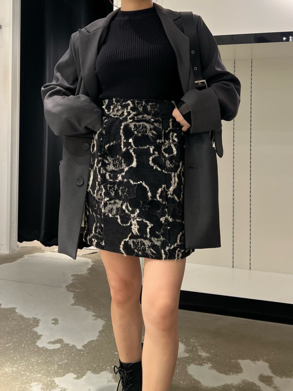 ブラック系のハンドバッグ、ブラウン系のブーツ、ブラック系のニット/セーターを着用したレディースの秋コーディネートの8枚目の写真