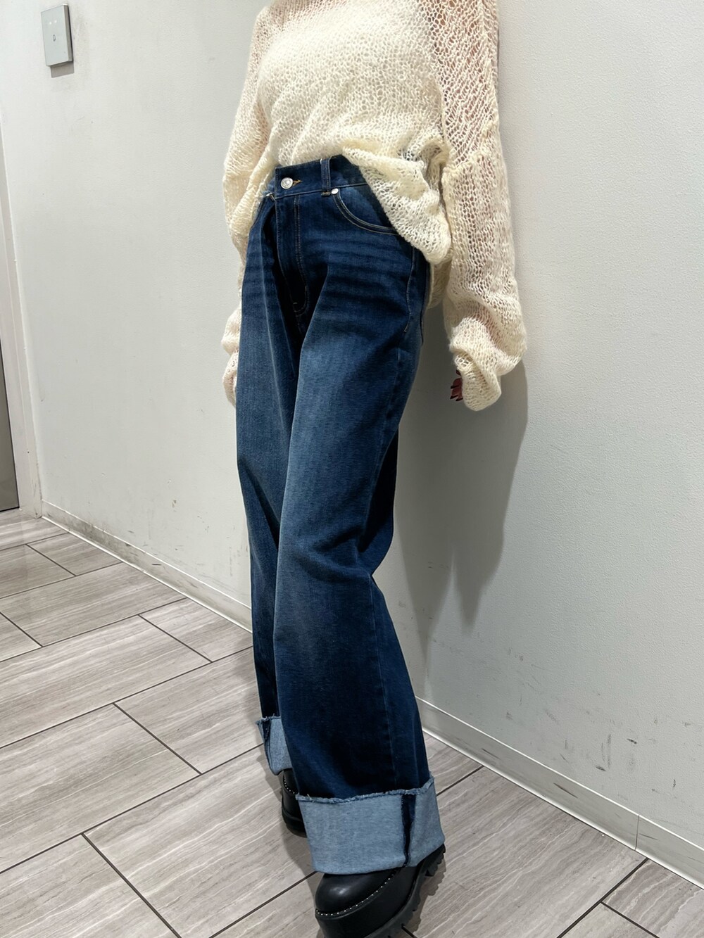 ブルー系のデニムパンツ、ホワイト系のニット/セーターを着用したレディースの秋コーディネートの6枚目の写真