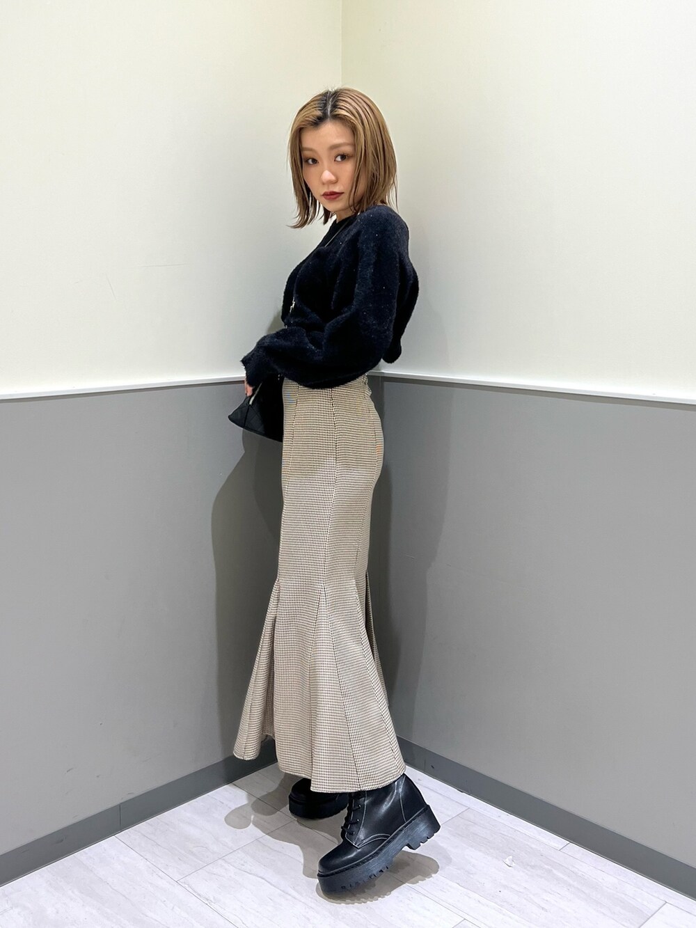 ブラック系のニット/セーター、その他のスカート、ブラック系のブーツを着用したレディースの冬コーディネートの3枚目の写真