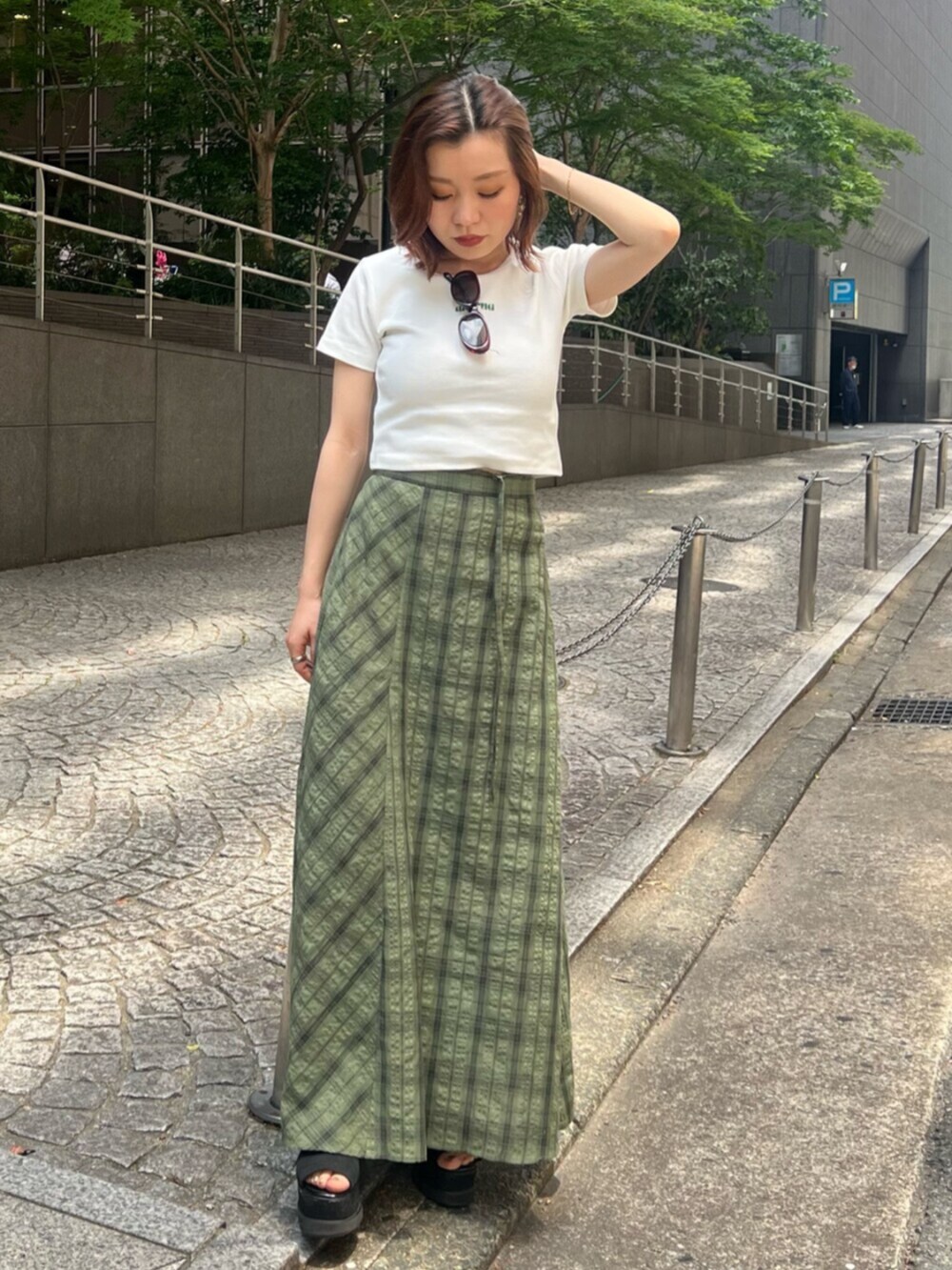 ブラック系のサンダル、ホワイト系のTシャツ/カットソー、グリーン系のスカートを着用したレディースの春コーディネートの4枚目の写真