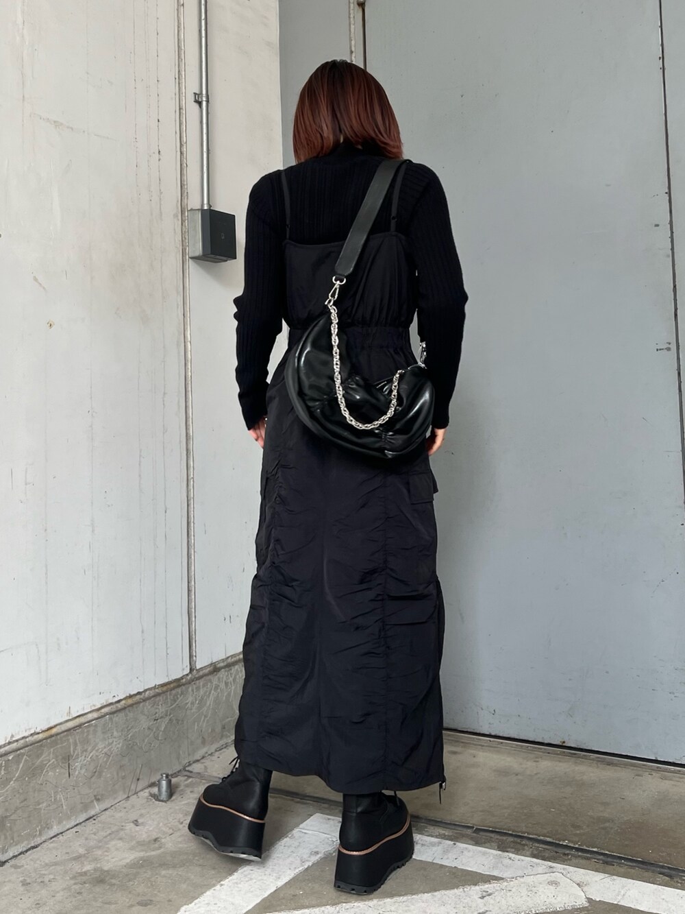 ブラック系のワンピース、ブラック系のブーツ、ブラック系のニット/セーターを着用したレディースの冬コーディネートの2枚目の写真