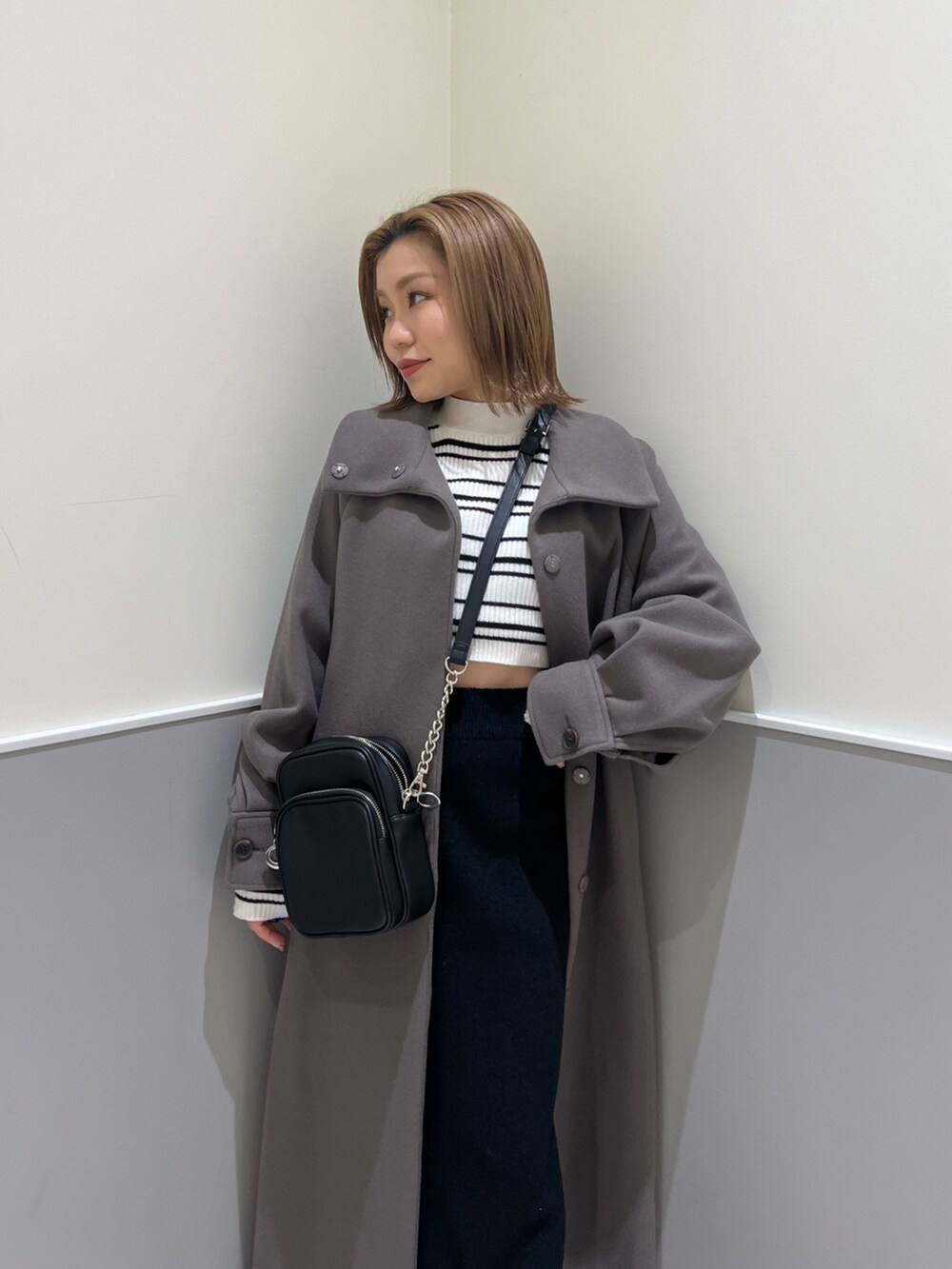 その他のニット/セーター、ブラック系のスカート、ブラウン系のステンカラーコートを着用したレディースの冬コーディネートの5枚目の写真