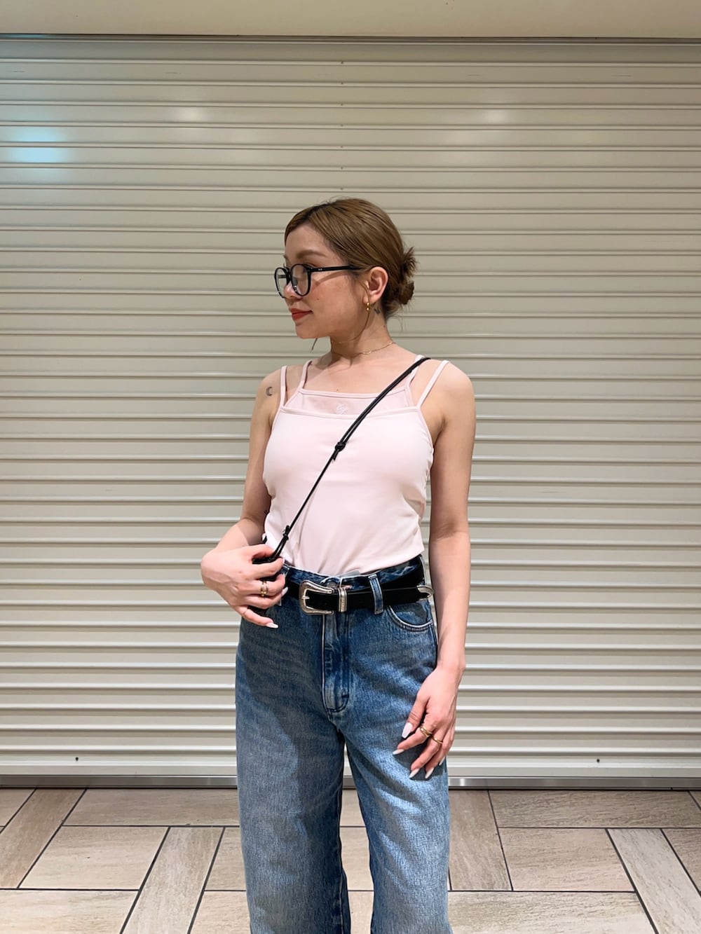 ピンク系のキャミソール、ブルー系のデニムパンツを着用したレディースの夏コーディネートの4枚目の写真