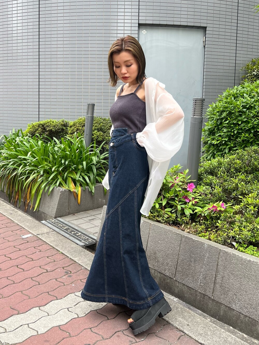 ホワイト系のシャツ/ブラウス、グレー系のニット/セーター、ブルー系のデニムスカートを着用したレディースの春コーディネートの2枚目の写真