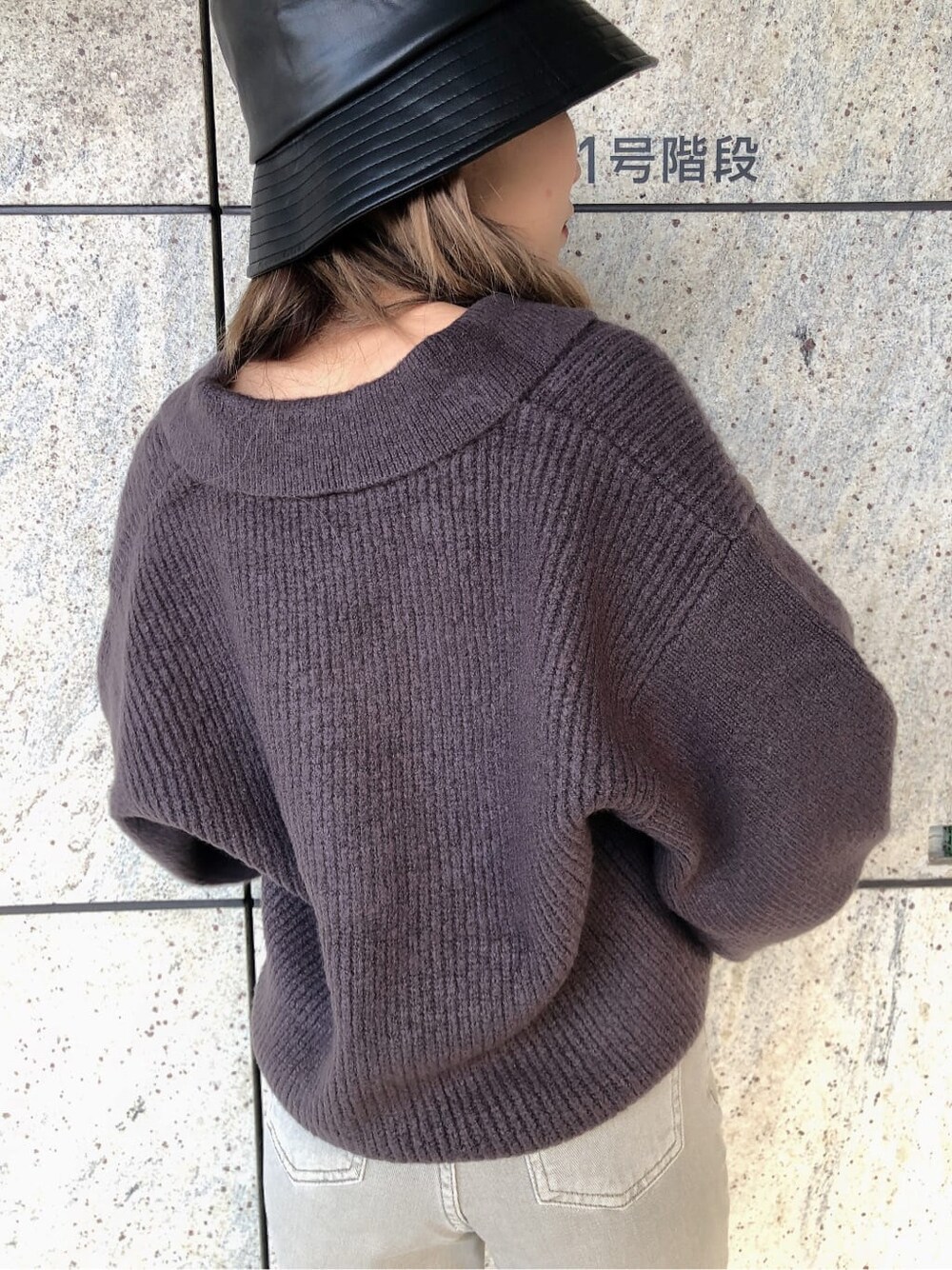 グレー系のデニムパンツ、グレー系のニット/セーター、ブラック系のハンドバッグを着用したレディースの秋コーディネートの5枚目の写真