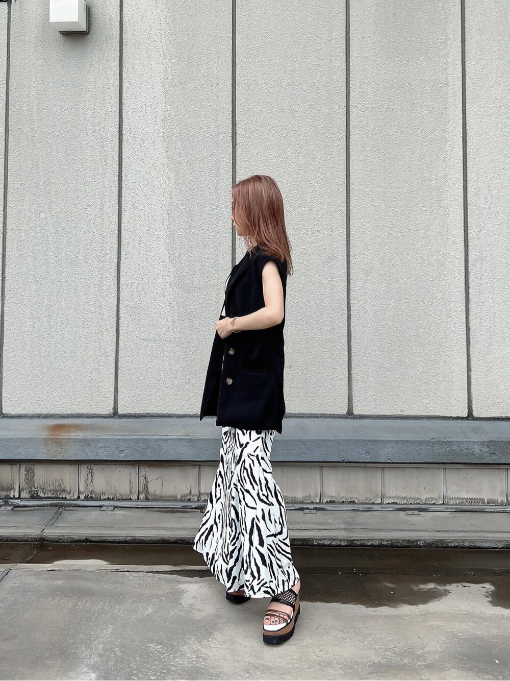 その他のサンダル、ブラック系のベスト、ホワイト系のハンドバッグを着用したレディースの夏コーディネートの8枚目の写真