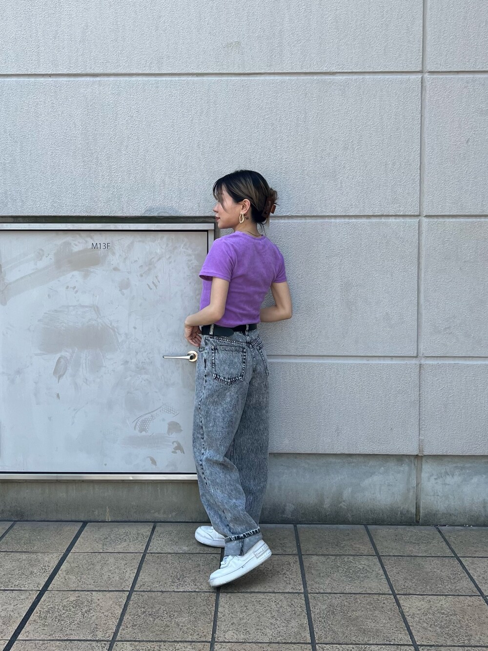 グレー系のデニムパンツ、パープル系のTシャツ/カットソー、ブラック系のベルトを着用したレディースの春コーディネートの4枚目の写真