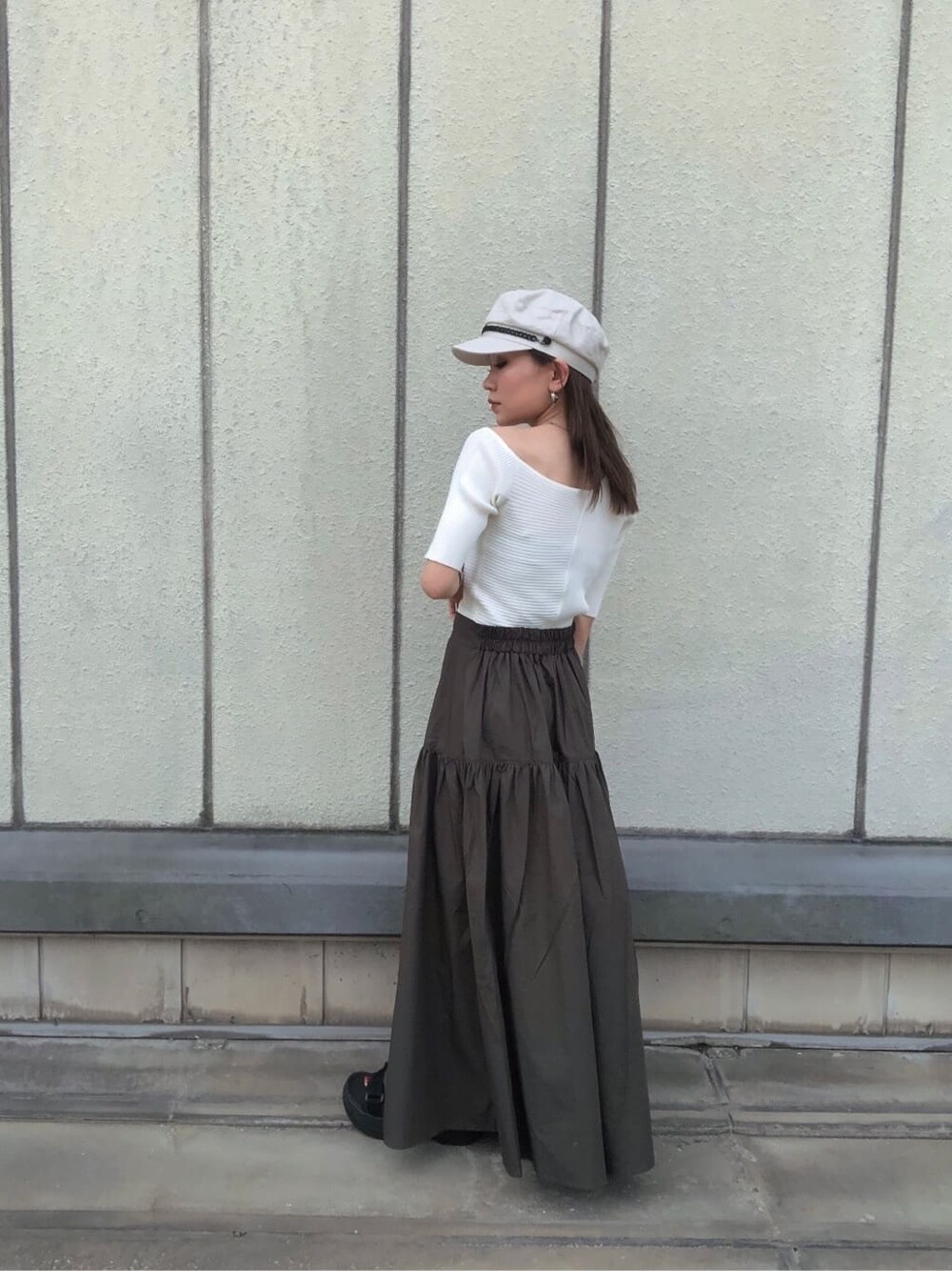 ブラック系のサンダル、ブラック系のショルダーバッグ、ホワイト系のニット/セーターを着用したレディースの夏コーディネートの3枚目の写真