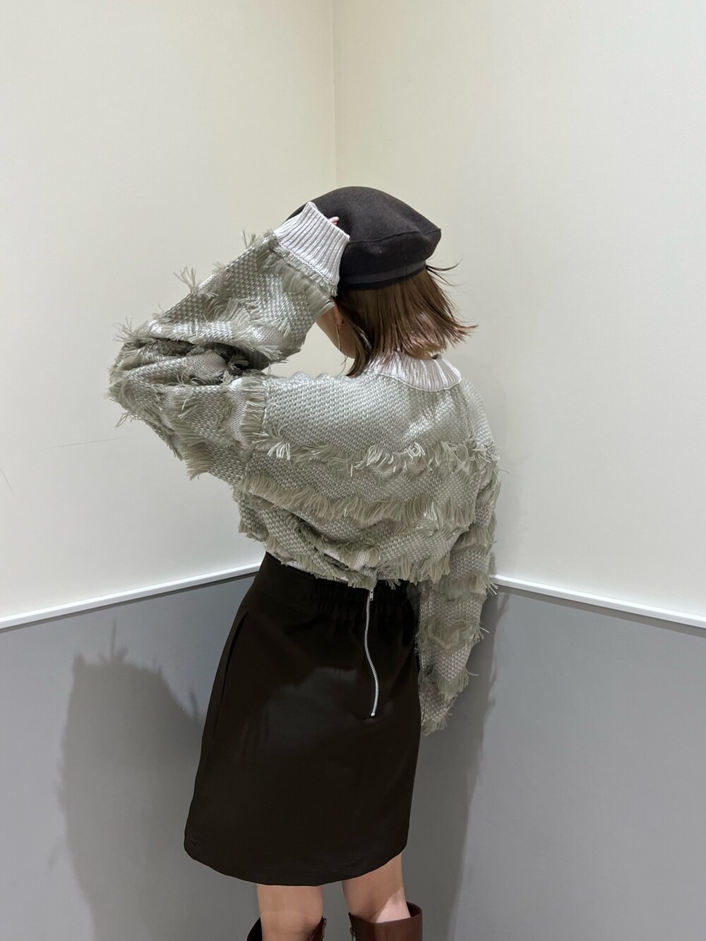 ベージュ系のニット/セーター、ブラウン系のスカート、ブラウン系のブーツを着用したレディースの秋コーディネートの6枚目の写真