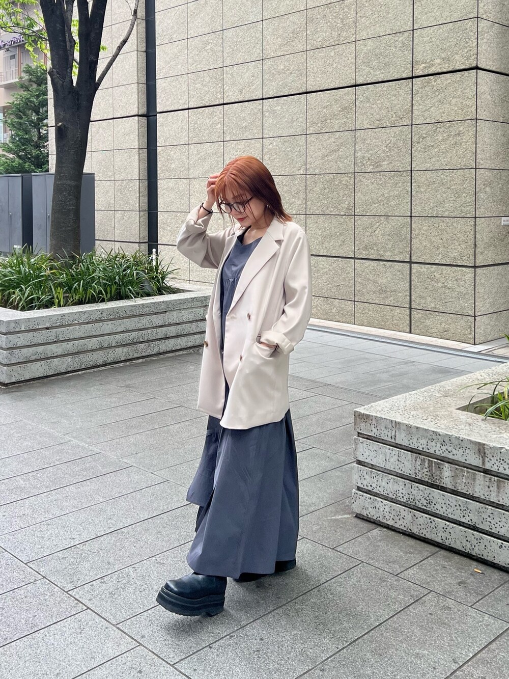 ベージュ系のテーラードジャケット、ブラウン系のニット/セーター、グレー系のワンピースを着用したレディースの春コーディネートの5枚目の写真