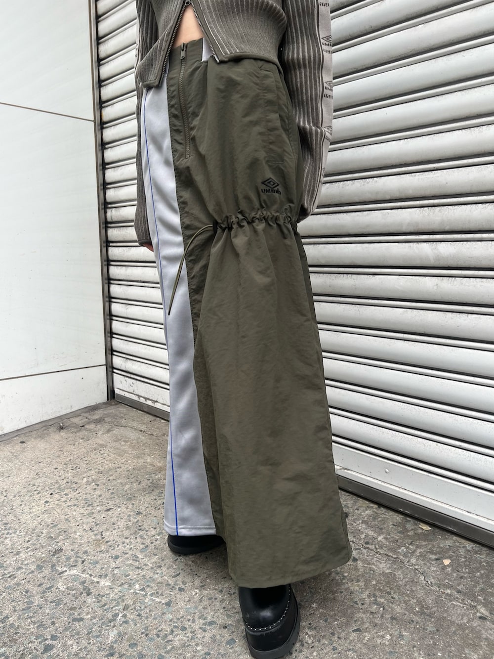 ブラック系のブーツ、グリーン系のニット/セーター、グリーン系のスカートを着用したレディースの秋コーディネートの7枚目の写真