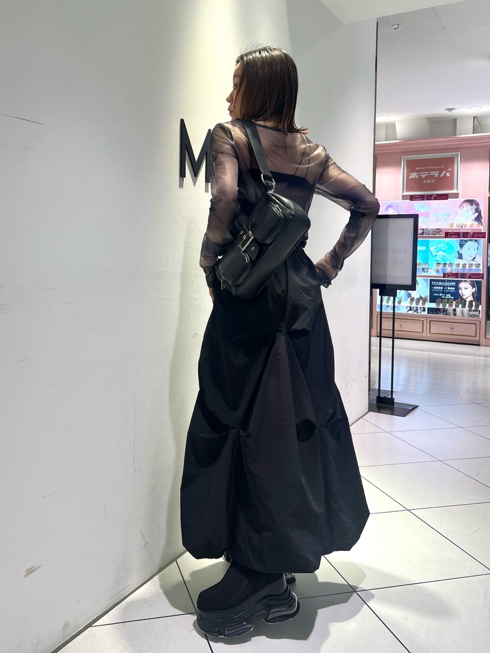 ブラック系のTシャツ/カットソー、ブラック系のスカート、ブラック系のブーツを着用したレディースの春コーディネートの4枚目の写真