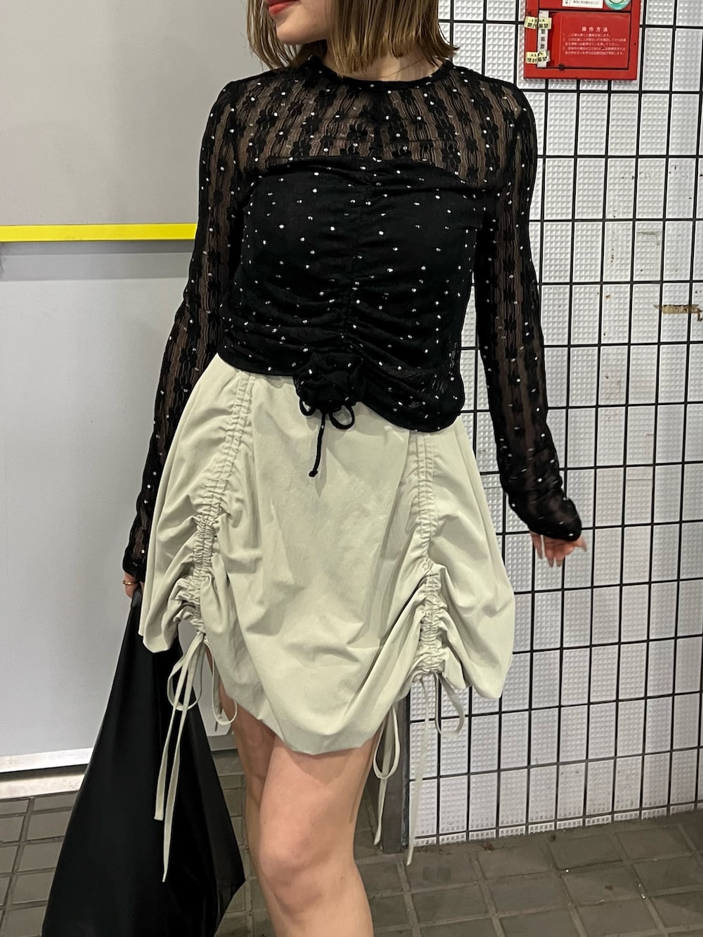 ブラック系のTシャツ/カットソー、グリーン系のスカートを着用したレディースの春コーディネートの6枚目の写真