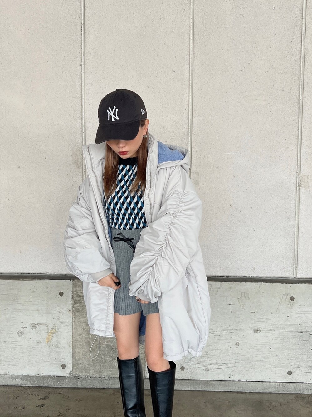 ホワイト系のブルゾン、ブラック系のニット/セーター、グレー系のスウェットパンツを着用したレディースの冬コーディネートの7枚目の写真