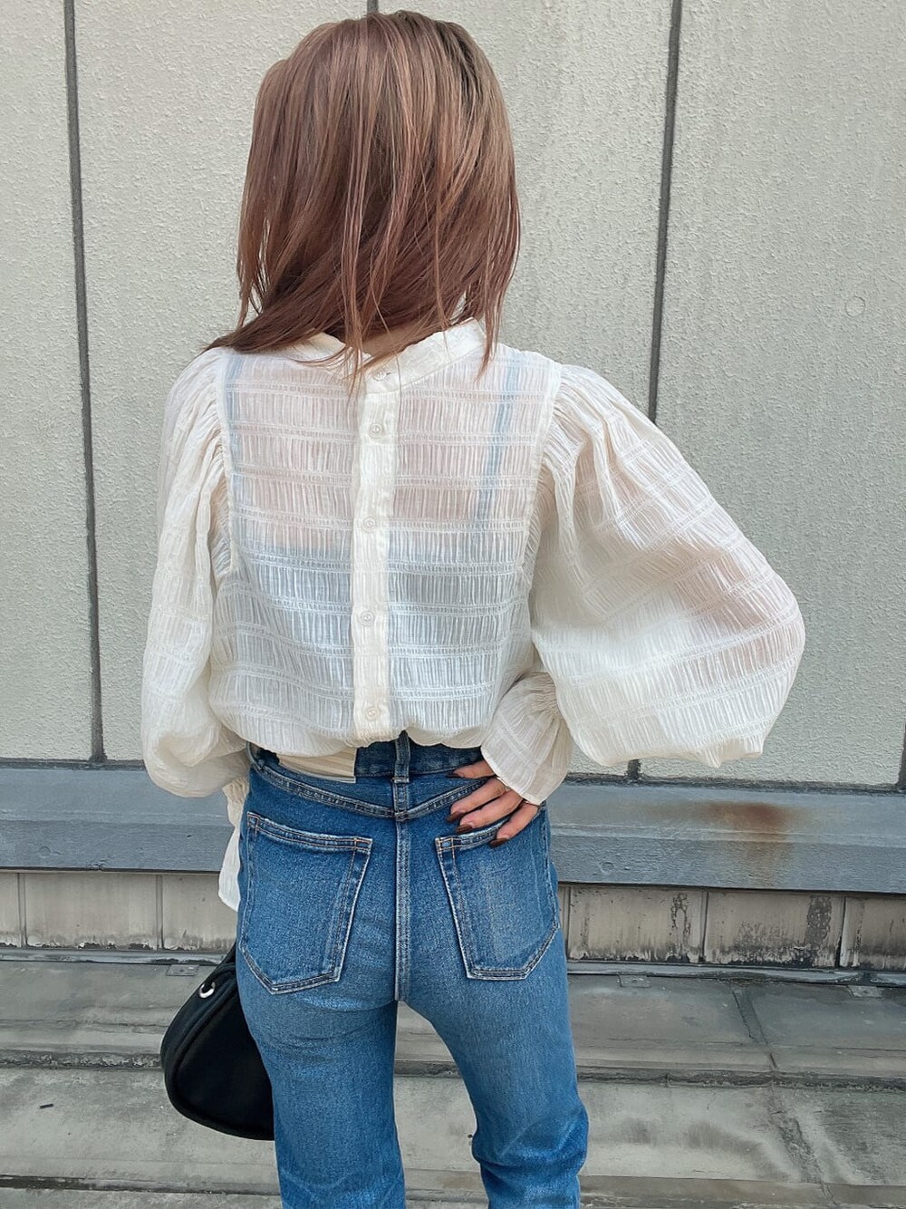 ブルー系のデニムパンツ、ホワイト系のシャツ/ブラウス、ブラック系のハンドバッグを着用したレディースの夏コーディネートの6枚目の写真