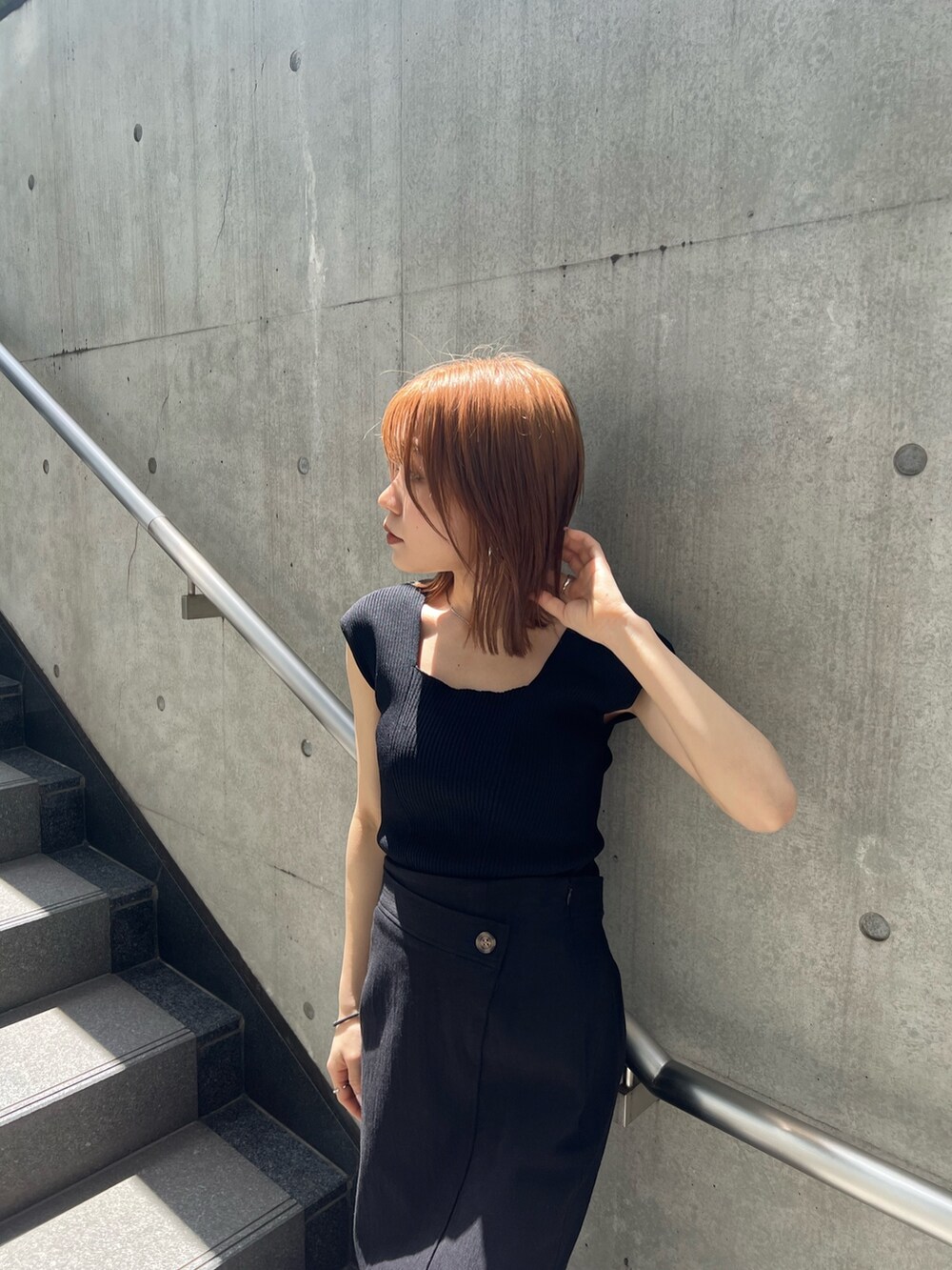 ブラック系のスカート、ブラック系のタンクトップ、ブラウン系のサンダルを着用したレディースの春コーディネートの5枚目の写真