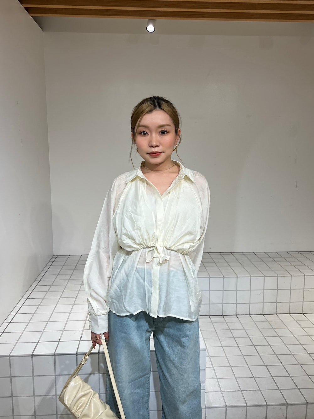 ホワイト系のシャツ/ブラウス、ブルー系のデニムパンツ、ブラック系のサンダルを着用したレディースの春コーディネートの4枚目の写真