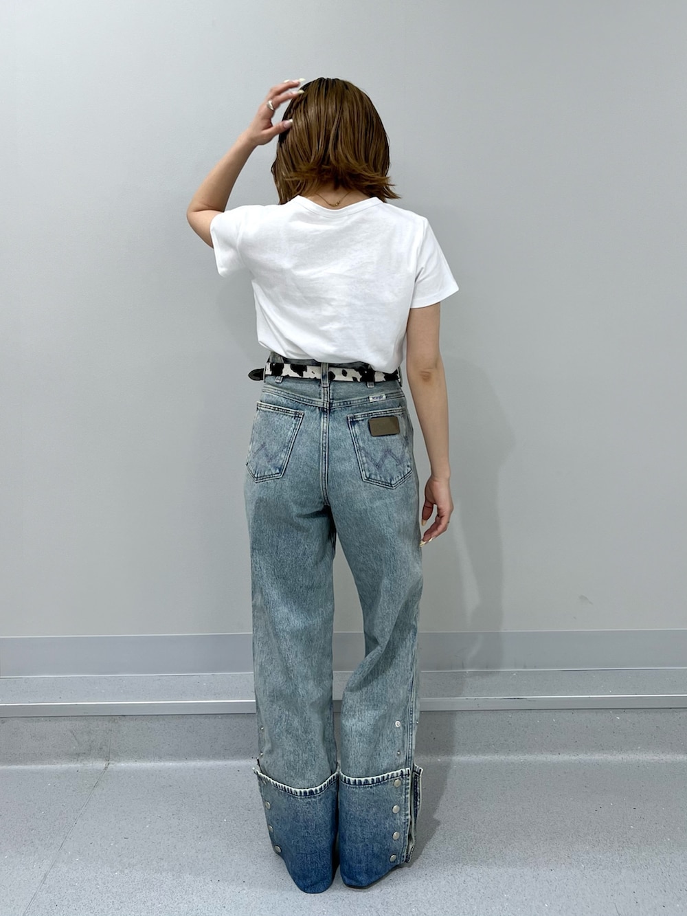 ブルー系のデニムパンツ、ホワイト系のTシャツ/カットソー、ブラウン系のブーツを着用したレディースの春コーディネートの3枚目の写真