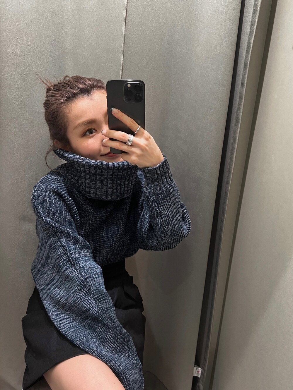 ブラック系のスカート、ブルー系のニット/セーター、ブラック系のブーツを着用したレディースの秋コーディネートの5枚目の写真